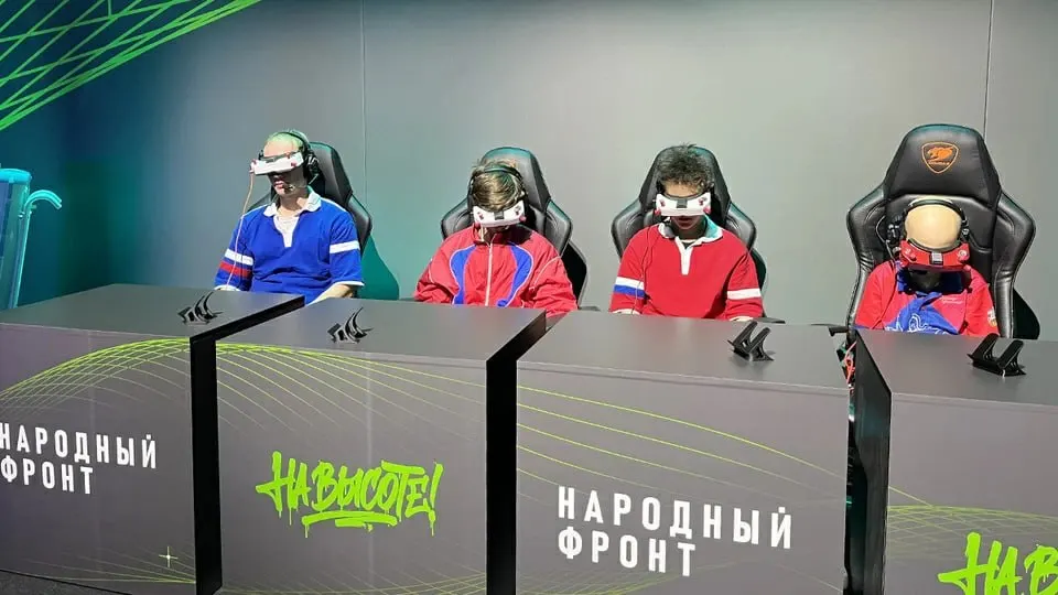 Новый норматив по управлению беспилотниками внедряют в пилотном режиме в нескольких регионах; планируется открыть классы по управлению дронами в 70 регионах; проект нацелен на развитие обороноспособности и технических навыков молодежи.